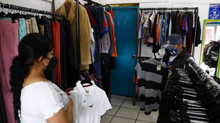 Una mujer vende ropa en un almacén en Quito, en abril de 2021. 