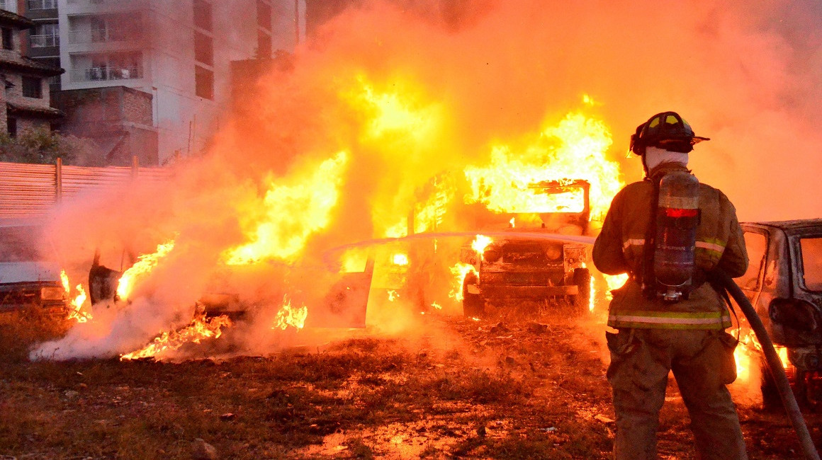 Un bombero trata de apagar un incendio provocado por los manifestantes en un estacionamiento en Colombia, el 28 de mayo de 2021.
