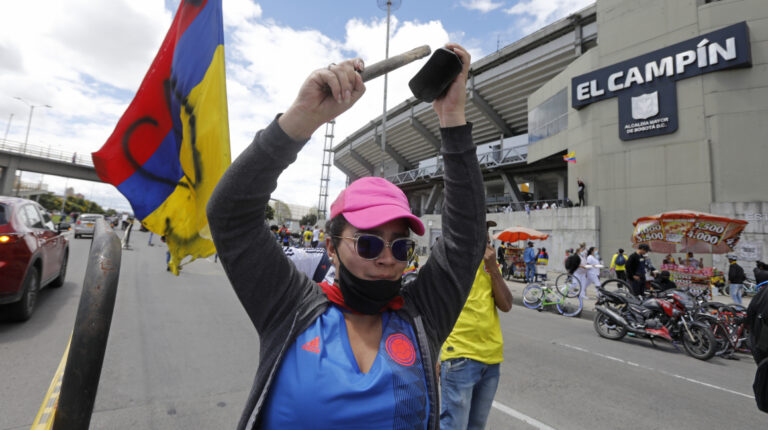 Una mujer participa en una protesta frente al estadio El Campín, durante una nueva jornadas de protestas del Paro Nacional el 19 de mayo de 2021, en Bogotá (Colombia). Los manifestantes concentrados afuera del estadio de la capital colombiana protestan contra la realización de la Copa América.
