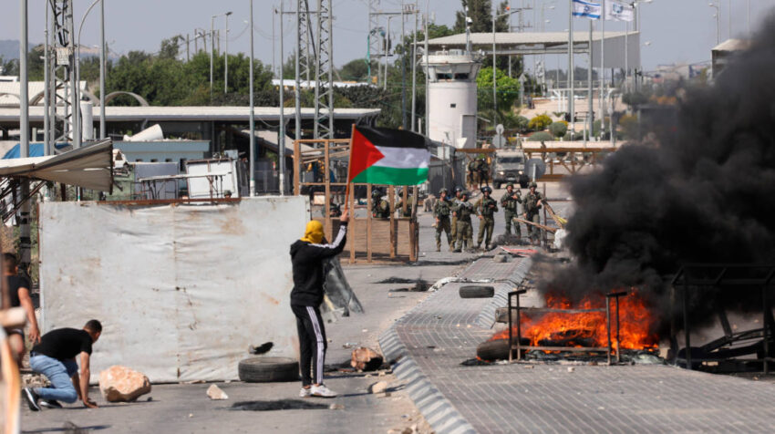 Ciudadanos palestinos protestan ante un grupo de militares israelíes en Gaza, el viernes 14 de mayo de 2021.