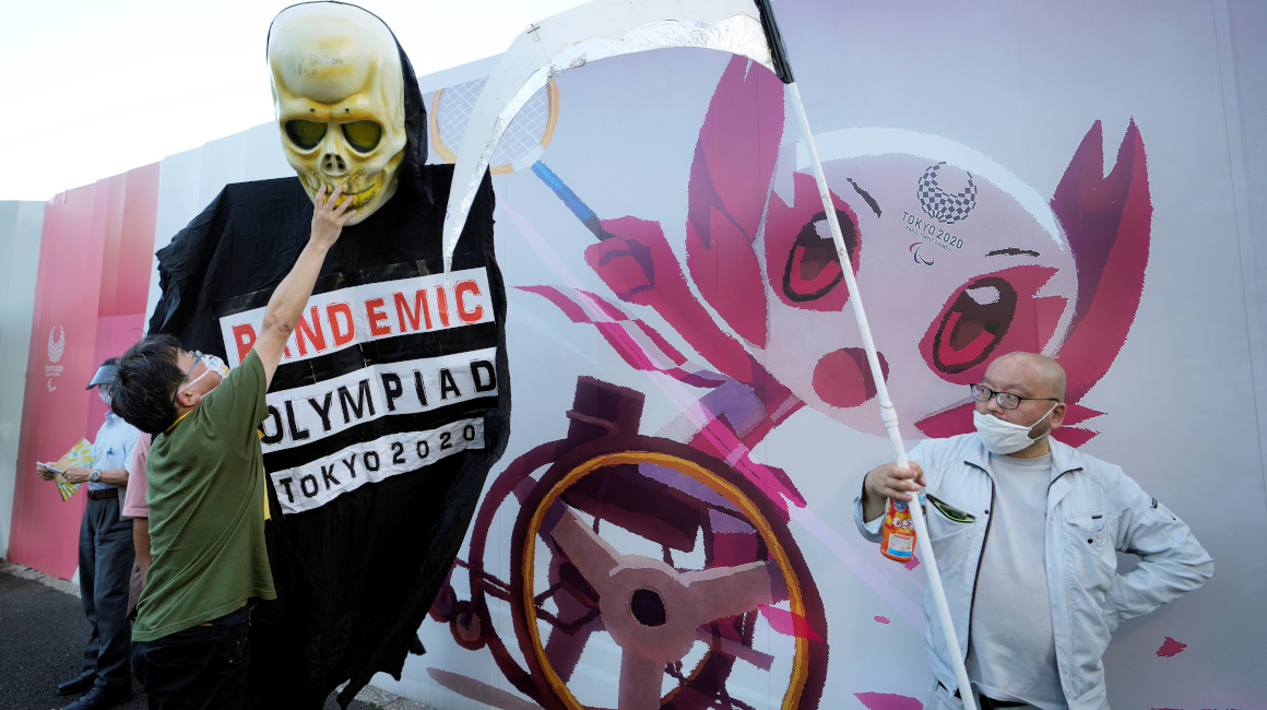 Dos personas participan de una protesta en contra de los Juegos Olímpicos, en Tokio, el 16 de julio de 2021.