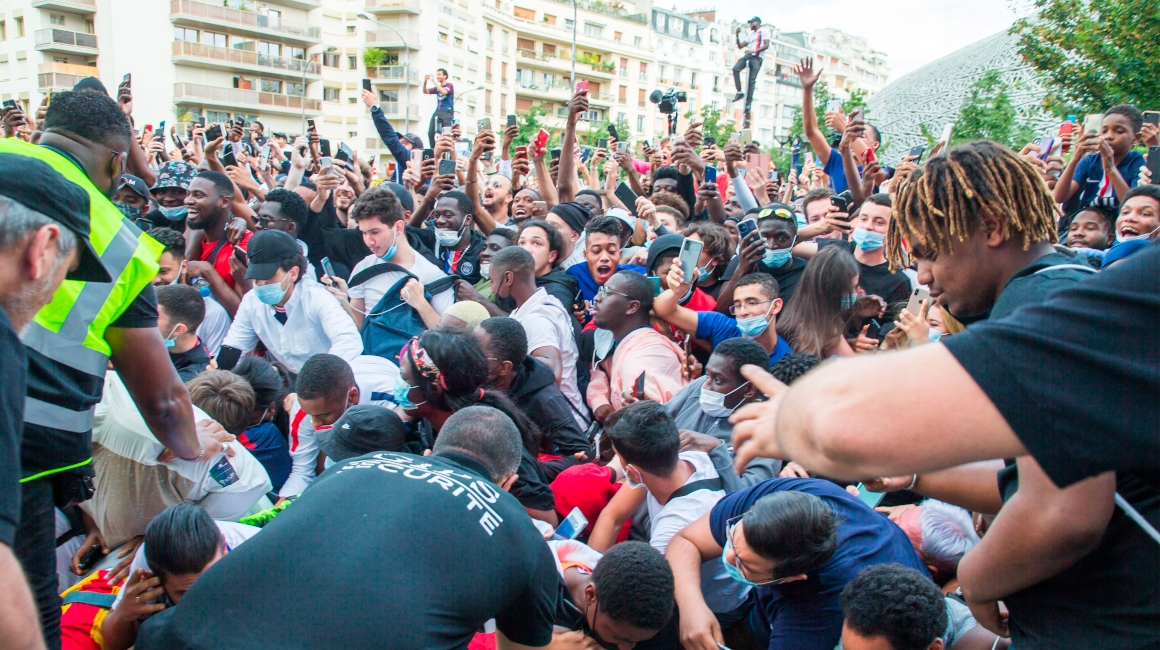 Aficionados del PSG tumban uno de los cercos de seguridad en las afueras del estadio. 