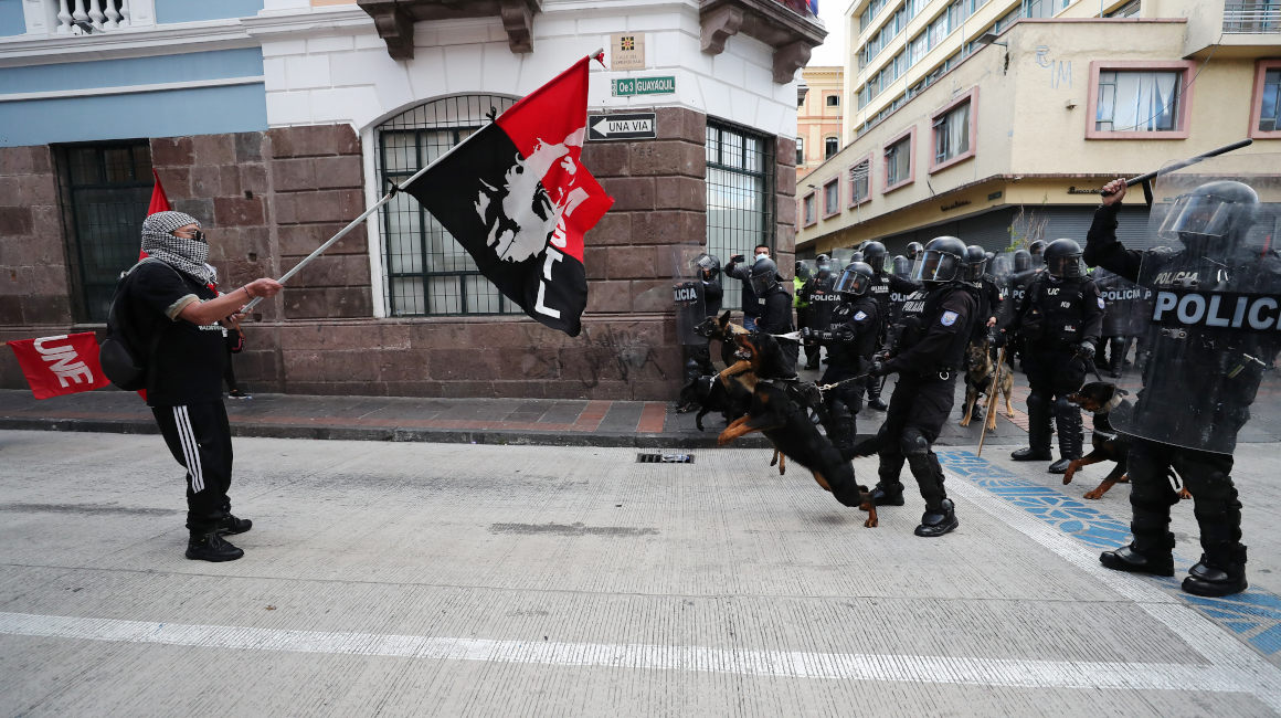 Policías con canes se enfrentan con manifestantes durante la protesta del 11 de agosto de 2021, en Quito.