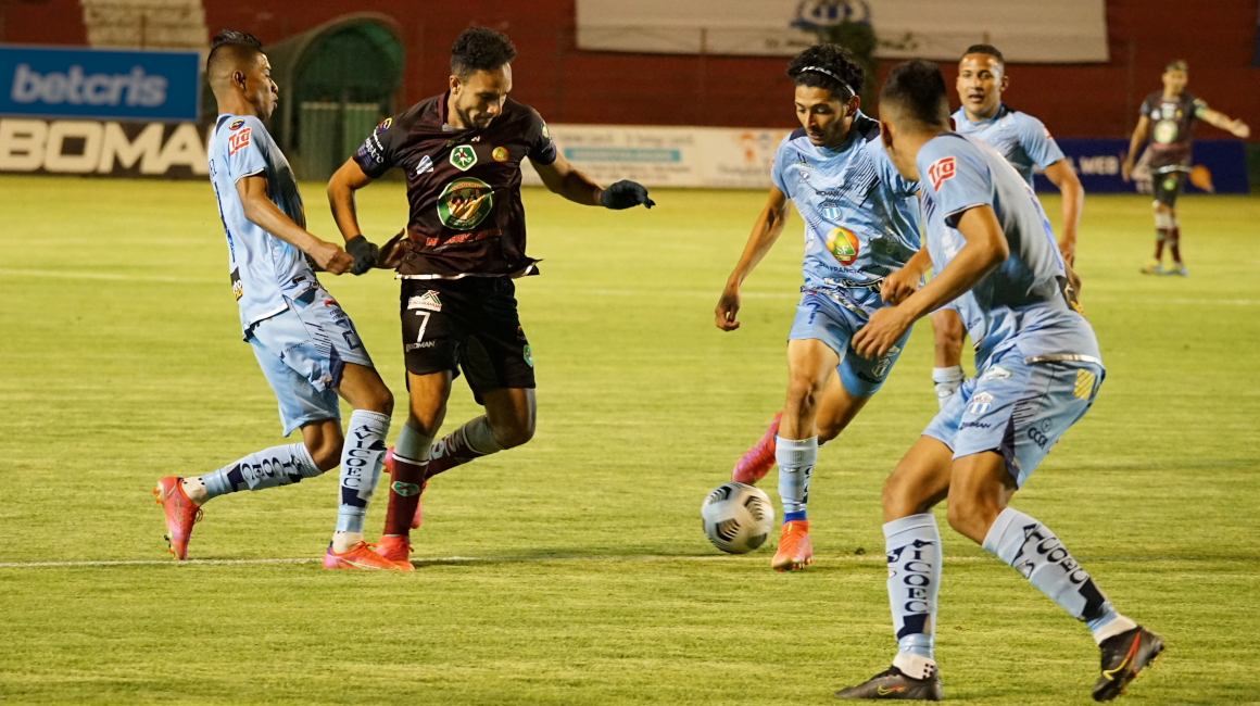 Tres jugadores de Macará intentan adueñarse de la pelota en el partido ante Mushuc Runa por la LigaPro, en Ambato, el 20 de agosto de 2021.