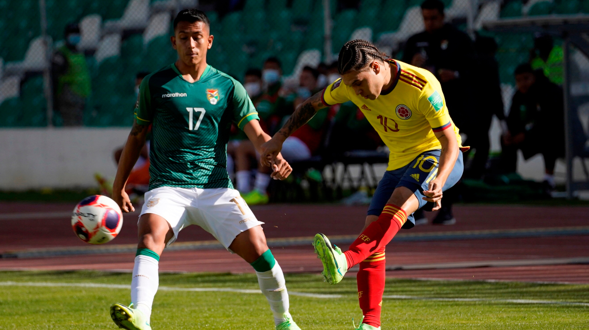 El colombiano Juan Quintero dispara el balón ante la marca del boliviano Roberto Fernández. 
