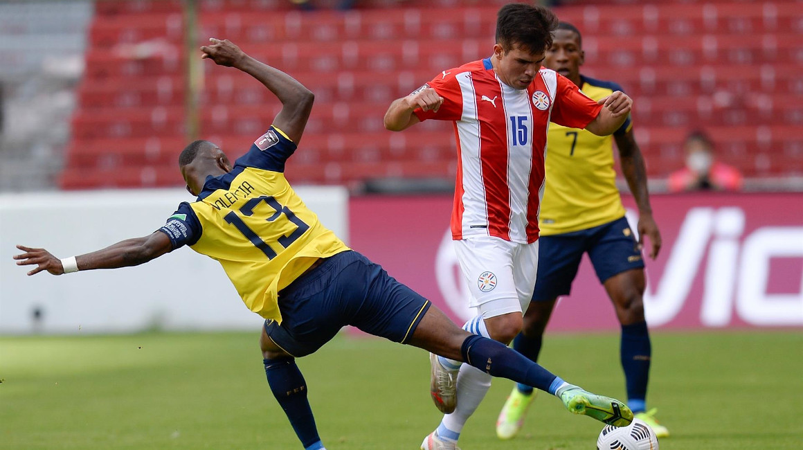 Enner Valencia de Ecuador cubre una pelota ante un futbolista paraguayo, en Quito, el 2 de septiembre de 2021.