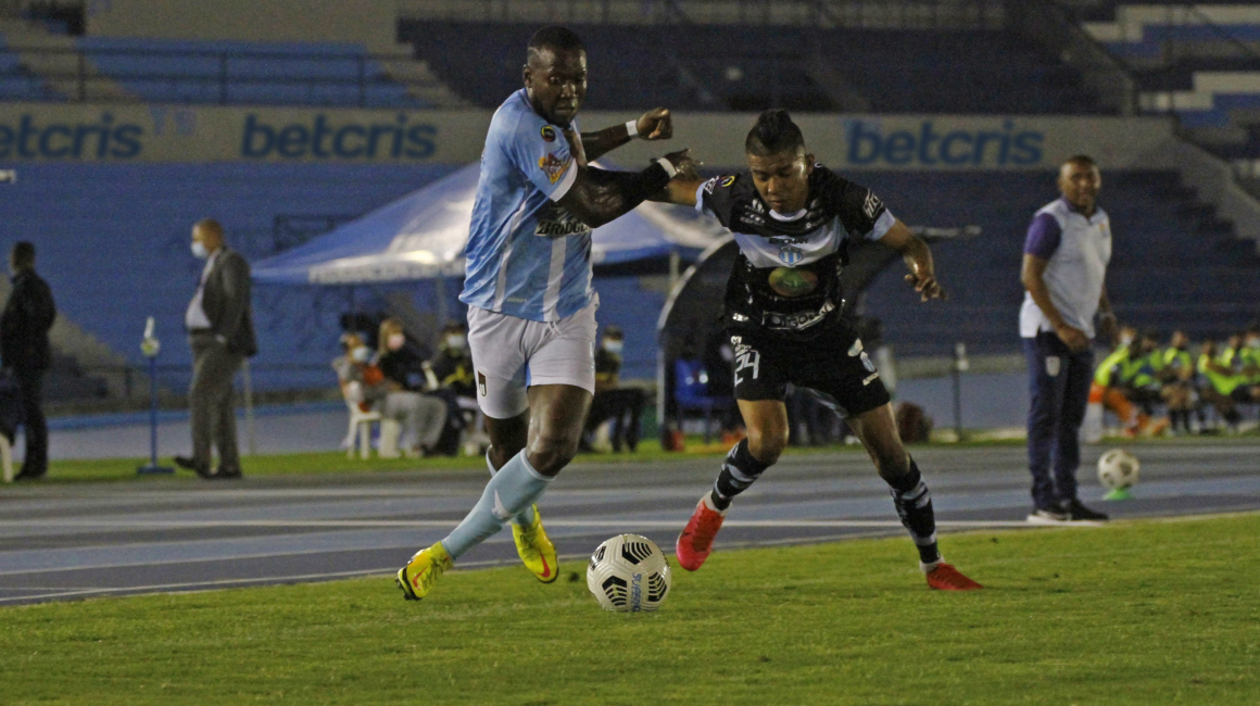 Bryan Hernández, de Macará, domina la pelota ante la marca de dos jugadores de 9 de Octubre, en partido por la Fecha 7 de la segunda etapa de la LigaPro, el sábado 18 de septiembre de 2021.