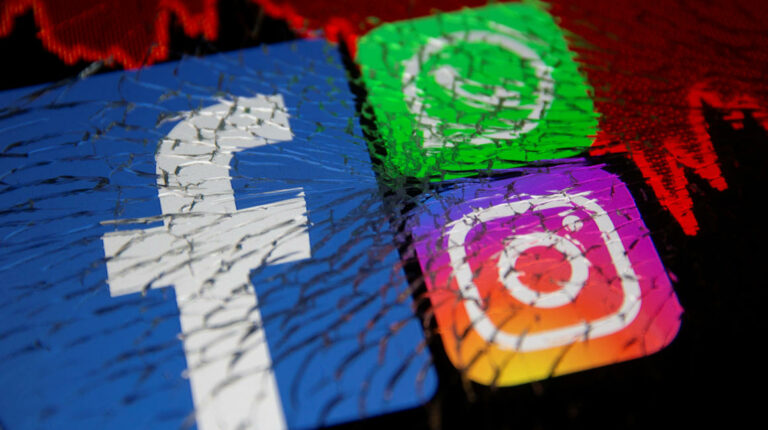 FILE PHOTO: Facebook, Whatsapp and Instagram logos and stock graph are displayed through broken glass in this illustration