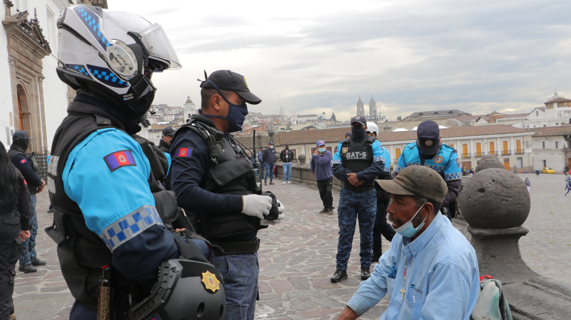 Policías Metropolitanos conversan con un hombre en situación de calle en el Centro Histórico de Quito, el 18 de octubre de 2021.