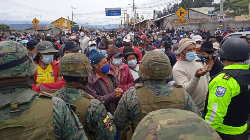 Manifestantes hablan con un grupo de policías y militares que quieren impedir el cierre de la vía en Panzaleo, Cotopaxi el 27 de octubre de 2021.