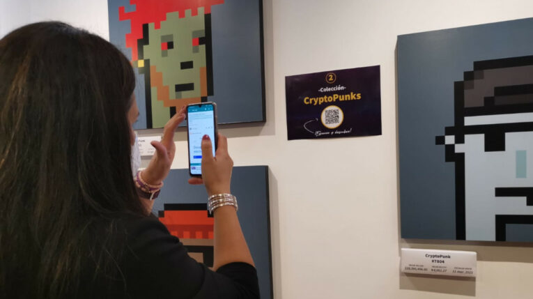 Una mujer abre un código QR en la galería de arte digital de la UIDE, el 24 de noviembre de 2021