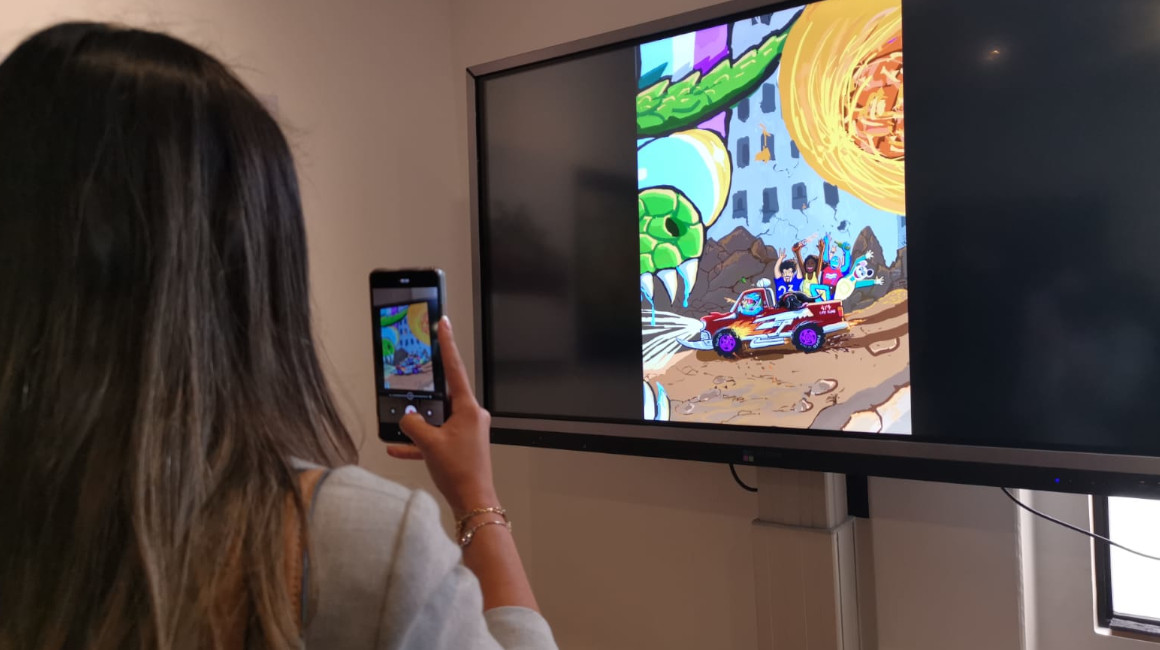 Una mujer toma una foto en la galería de arte digital de la UIDE, el 24 de noviembre de 2021
