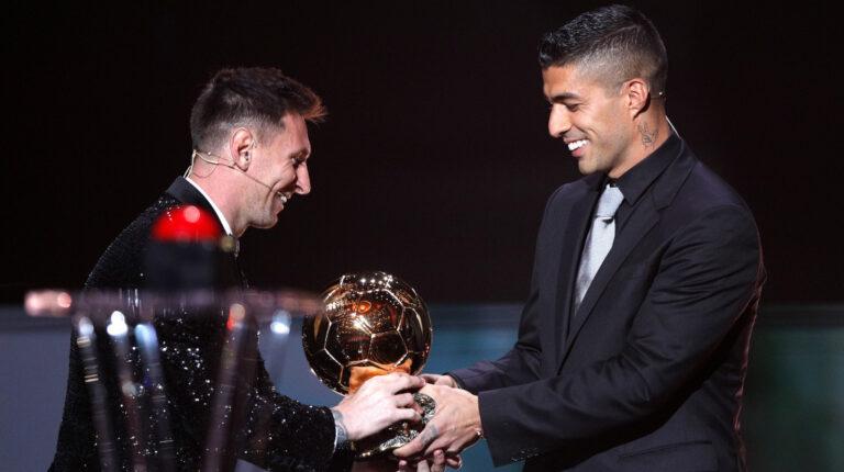 El jugador del PSG Lionel Messi recibe el Balón de Oro de manos de su excompañero de Barcelona, Luis Suárez, en la ceremonia del Balón de Oro 2021.