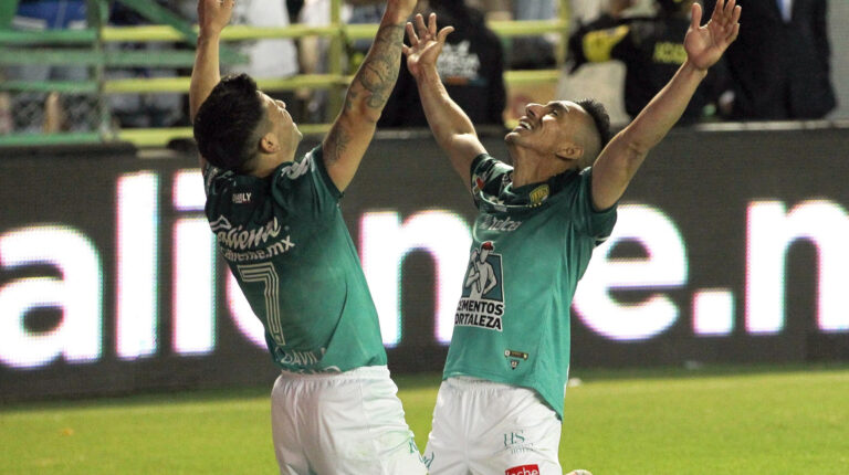 Víctor Dávila y Ángel Mena celebran uno de los goles del León, en la primera final de la Liga MX, ante el Atlas, el jueves 9 de diciembre de 2021.