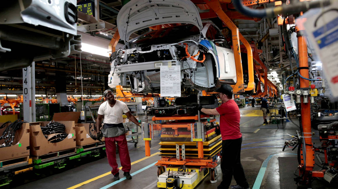 Trabajadores de montaje de General Motors conectan un paquete de baterías debajo de un vehículo Chevrolet Bolt EV parcialmente ensamblado en la línea de montaje en Orion Assembly en Michigan, el 19 de marzo de 2018.
