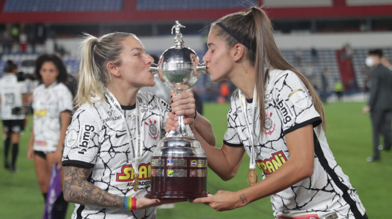 Carina Gomes (i) y Jheniffer da Silva Cordinali de Corinthians besan el trofeo luego de ganar la final de la Copa Libertadores Femenina 2021.