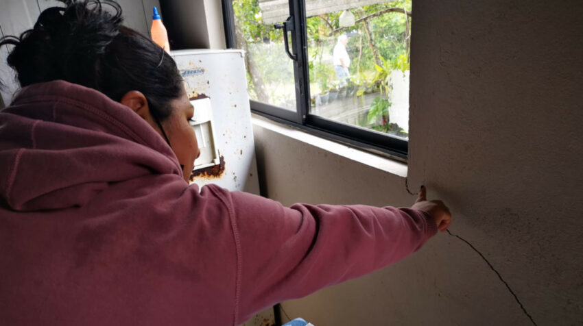 La moradora Adriana Carranza indica los daños que sufre su casa, en San Luis.