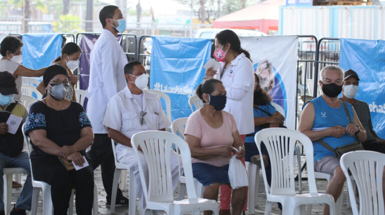 Personas sentadas en un centro de salud de Guayaquil esperan recibir la vacuna contra el Covid-19, el 6 de diciembre de 2021.