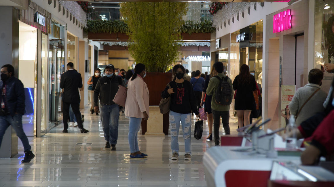 Personas caminan en un centro comercial en el centro norte de Quito, en diciembre de 2021.