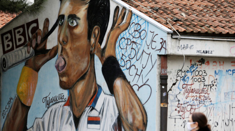 Una mujer pasa junto a un mural del tenista serbio Novak Djokovic en Belgrado, Serbia, el 6 de enero de 2022.