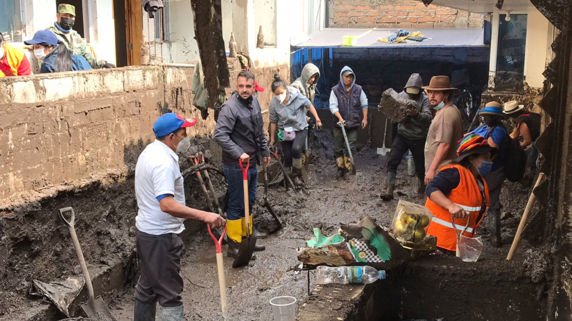 Varios voluntarios en las tareas de limpieza de calles tras el aluvión, en Quito, el 2 de febrero de 2022.