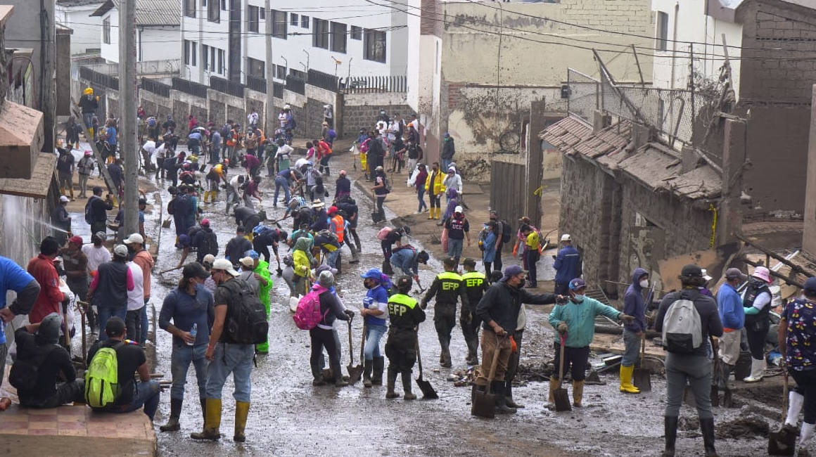Personas limpian los escombros en los barrios de La Comuna y La Gasca, en Quito, el 5 de febrero de 2022.