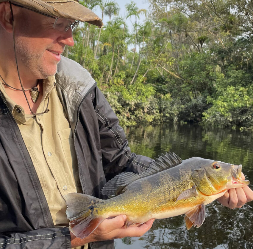 Investigador sosteniendo un pez de la Amazonía. 