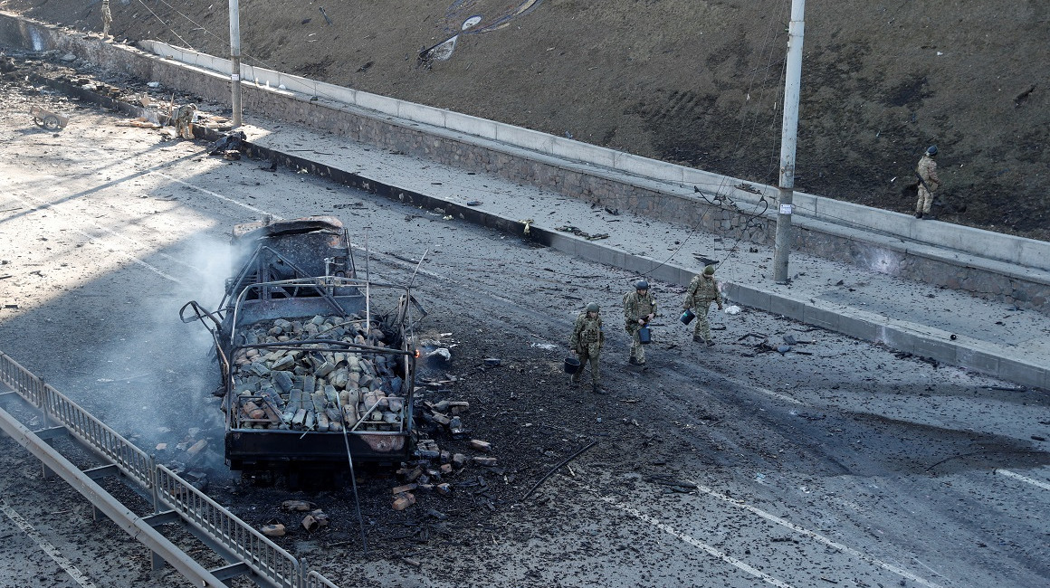 Soldados ucranianos caminan junto a un camión destruido por misiles rusos en las afueras de Kiev, el 27 de febrero de 2022.