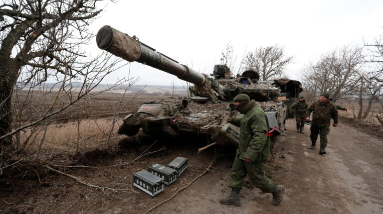 Separatistas prorrusos caminan cerca de un tanque abandonado en una carretera entre los asentamientos controlados por los separatistas de Mykolaivka (Nikolaevka) y Buhas (Bugas), mientras continúa la invasión rusa de Ucrania, en la región de Donetsk, Ucrania, el 1 de marzo de 2022.