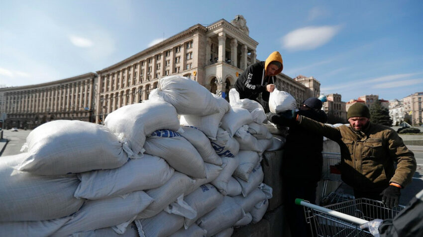 Dos soldados civiles colocan sacos de arena en un muro de contención en Kiev, el 13 de marzo de 2022.