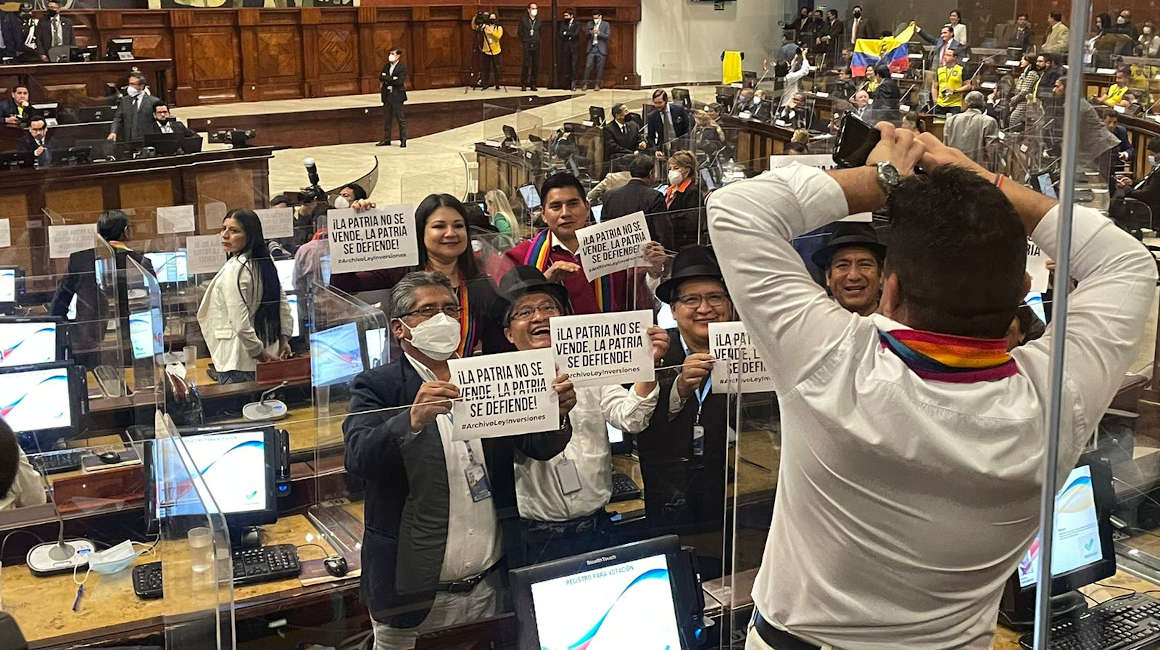 Asambleístas de Pachakutik muestan carteles contra la Ley de Inversiones, el 24 de marzo de 2022, en el Pleno de la Asamblea Nacional.