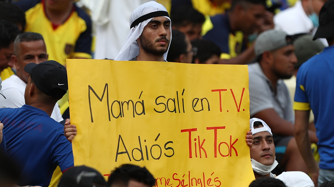 Un aficionado con vestimenta catarí muestra un cartel antes del inicio del Ecuador - Argentina por las Eliminatorias.