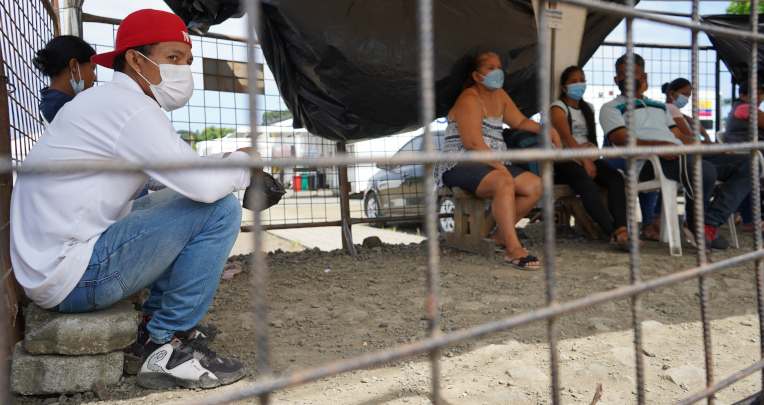 Familiares de pacientes esperan en la calle afuera de la unidad de salud móvil. Pedernales, 7 de abril de 2022.