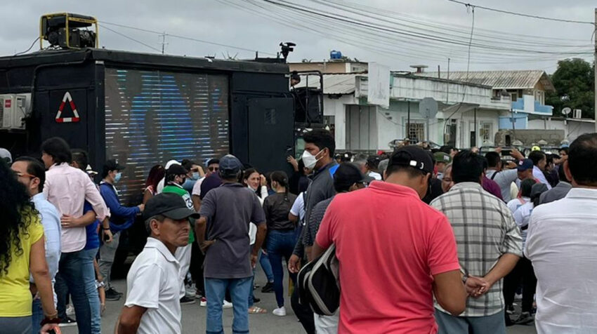 Simpatizantes de Jorge Glas conversan junto a una pantalla gigante en los exteriores de la Corte Provincial de Santa Elena, el 18 de mayo de 2022.