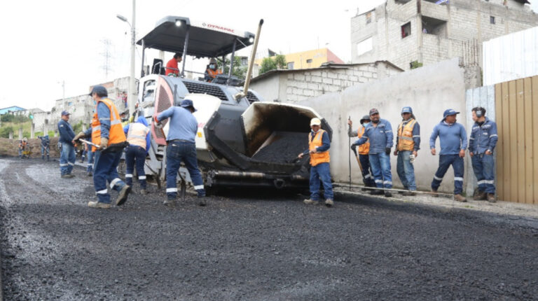Funcionarios de la Empresa de Obras Públicas de Quito pavimentan una avenida del sur de Quito, el 6 de junio de 2022.