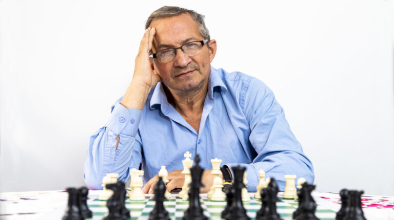 El Maestro Plinio Pazos posa con un juego de ajedrez, en su casa, en Quito, el 8 de junio de 2022.