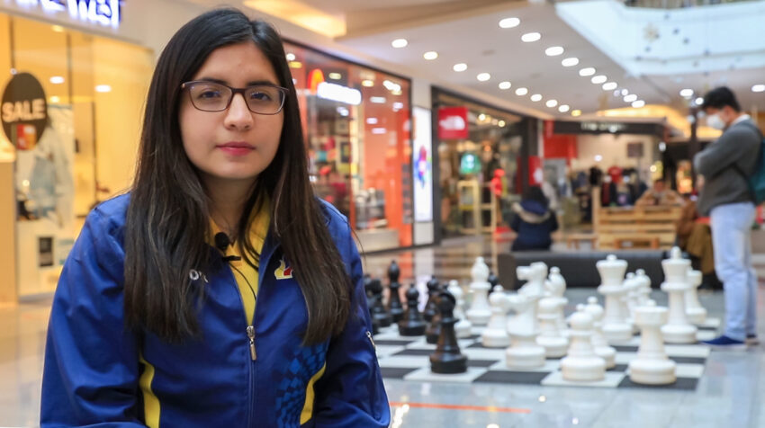 Anahí Ortiz posa junto a las piezas del tablero gigante de ajedrez, en un centro comercial de Quito, el 10 de noviembre de 2021. 