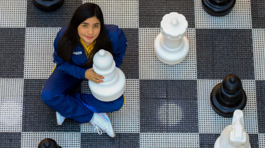 Anahí Ortiz posa junto a las piezas del tablero gigante de ajedrez, en un centro comercial de Quito, el 10 de noviembre de 2021.
