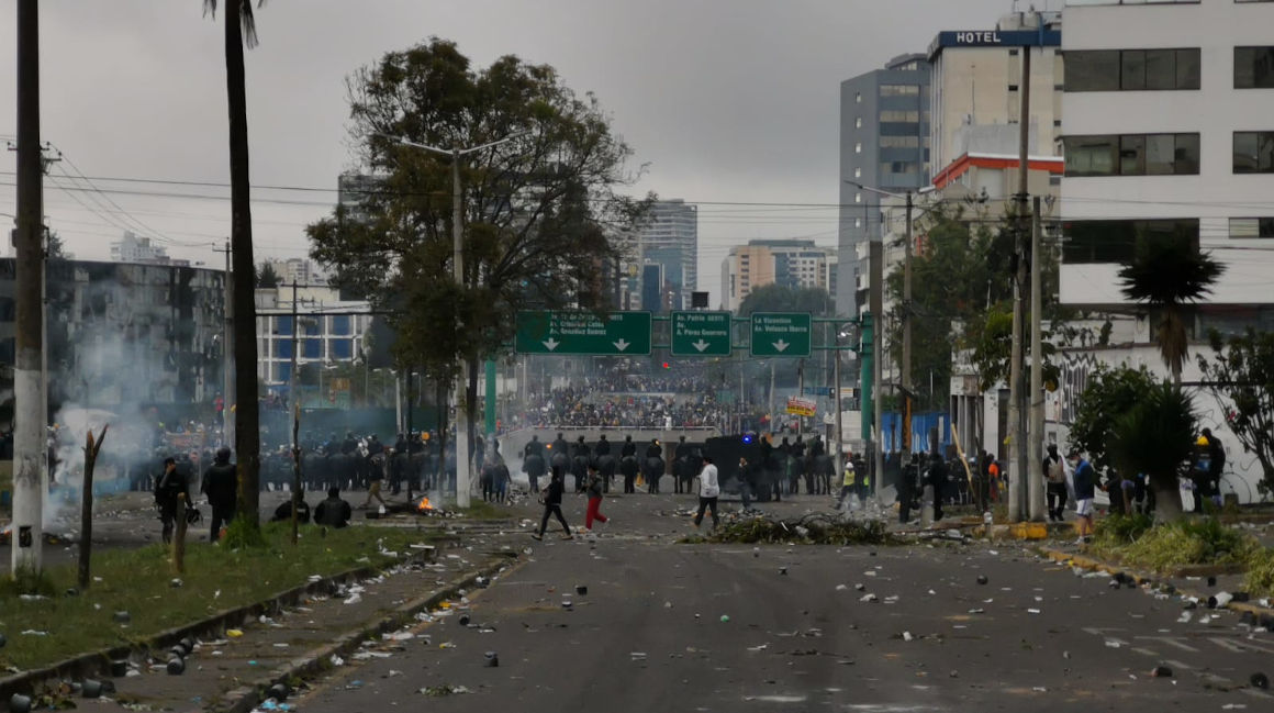 Policías miran a los manifestantes replegados en las inmediaciones de la Casa de la Cultura, en Quito, el 24 de junio de 2022.
