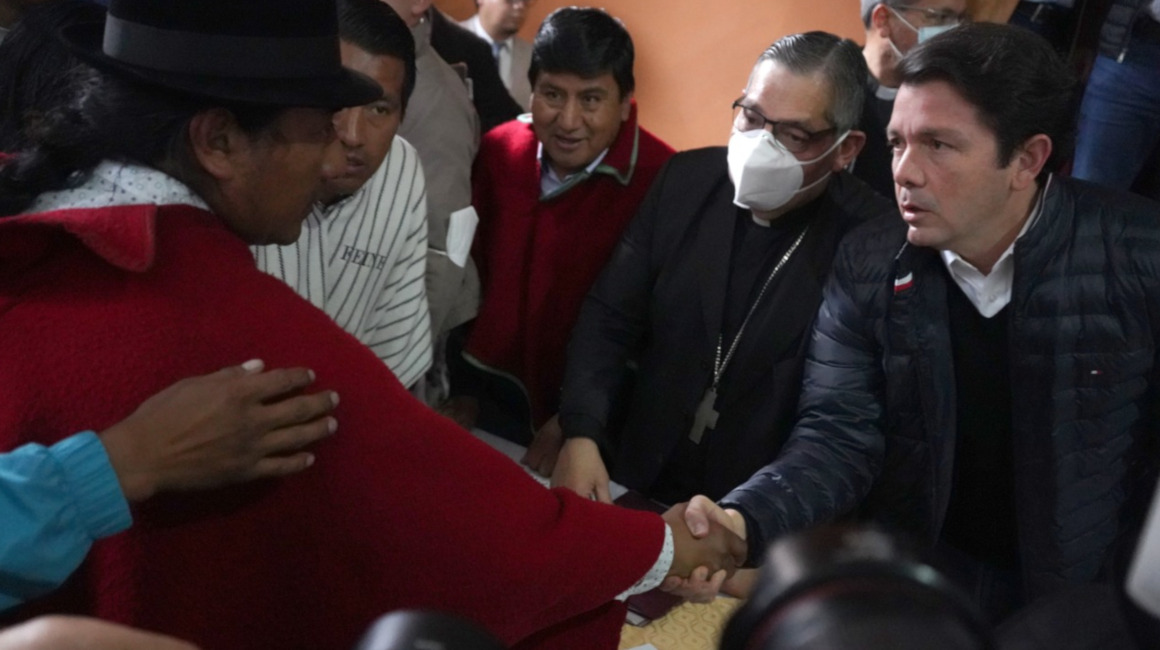 Leonidas Iza, presidente de la Conaie, y Francisco Jiménez, ministro de Gobierno, estrechan sus manos luego de la firma del acta por la paz, el 30 de junio de 2022, en Quito.