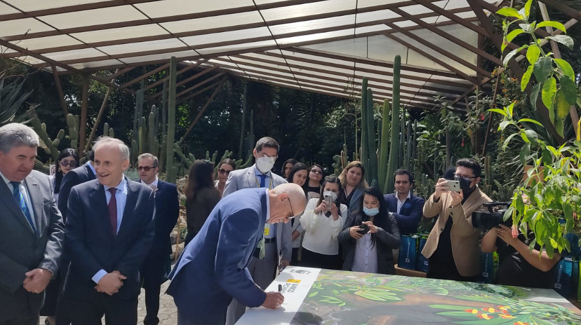 Antonio Acosta, presidente de Banco Pichincha, firma un cuadro durante la presentación del programa Suscríbete al planeta.