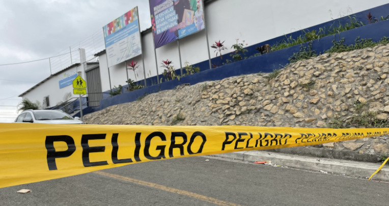 Padres de familia colocan cintas para limitar el acceso de vehículos a la puerta de una unidad educativa en Flor de Bastión, Guayaquil, 9 de agosto de 2022.