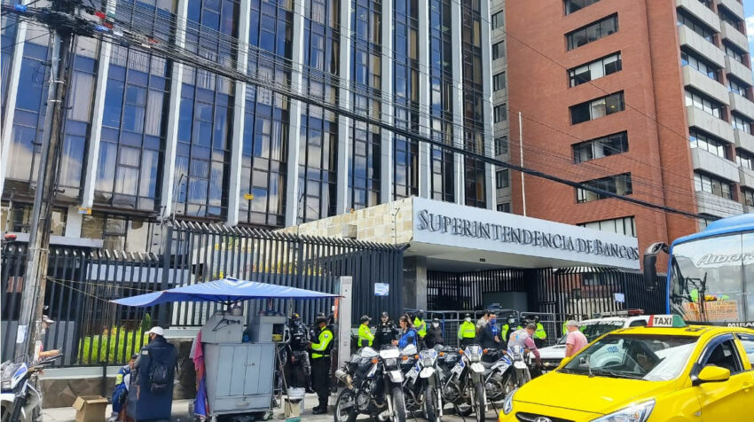 Oficiales de la Policía Nacional custodian la entrada del edificio de la Superintendencia de Bancos, en Quito. Foto del 15 de agosto de 2022.