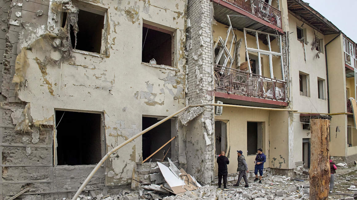 Ciudadanos observan los destrozos en un edificio residencial bombardeado por fuerzas rusas en la ciudad de Kharkiv, Ucrania, el 12 de septiembre de 2022.