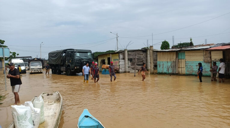 Personas caminan por un sector de Balao, cantón de Guayas, en las inundaciones de febrero de 2022. 