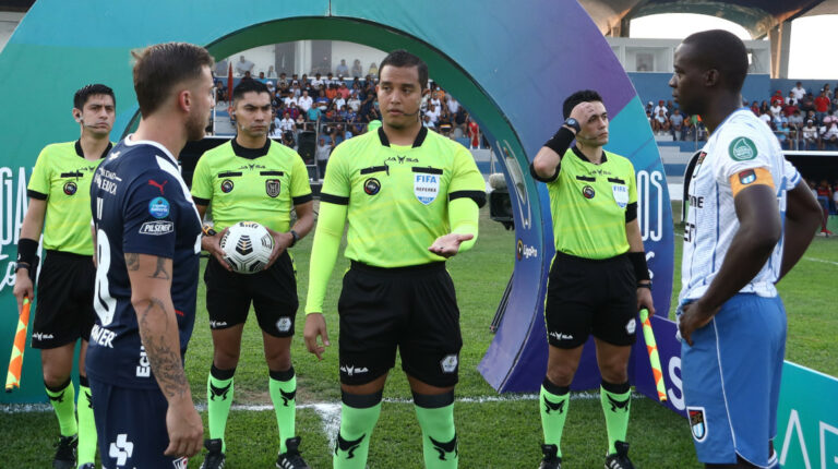 La terna arbitral, comandada por Marlon Vera, habla con los capitanes de Liga de Quito y 9 de Octubre antes del partido de la Fecha 12 de la LigaPro, el 1 de octubre de 2022.
