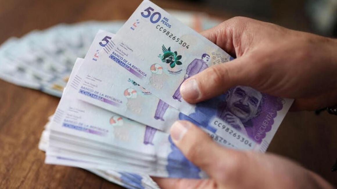 Una persona cuenta billetes de 50.000 pesos colombianos, en Bogotá, en 2022.