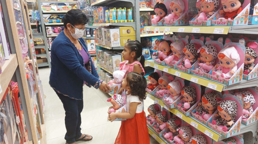 Uma mujer y dos niñas sostienen juguetes en un almacén de Ecuador, en octubre de 2022. 