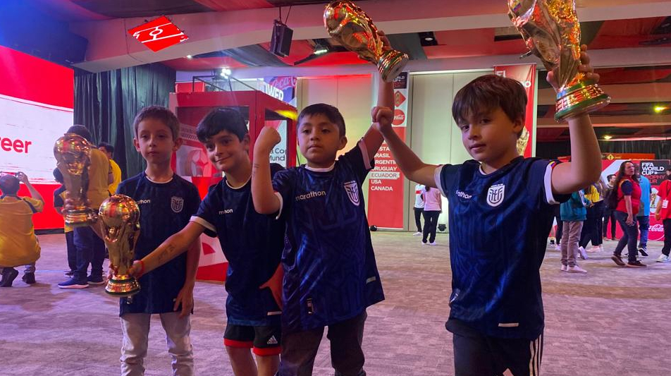 Niños posan con réplicas del trofeo en el evento de la Copa del Mundo.