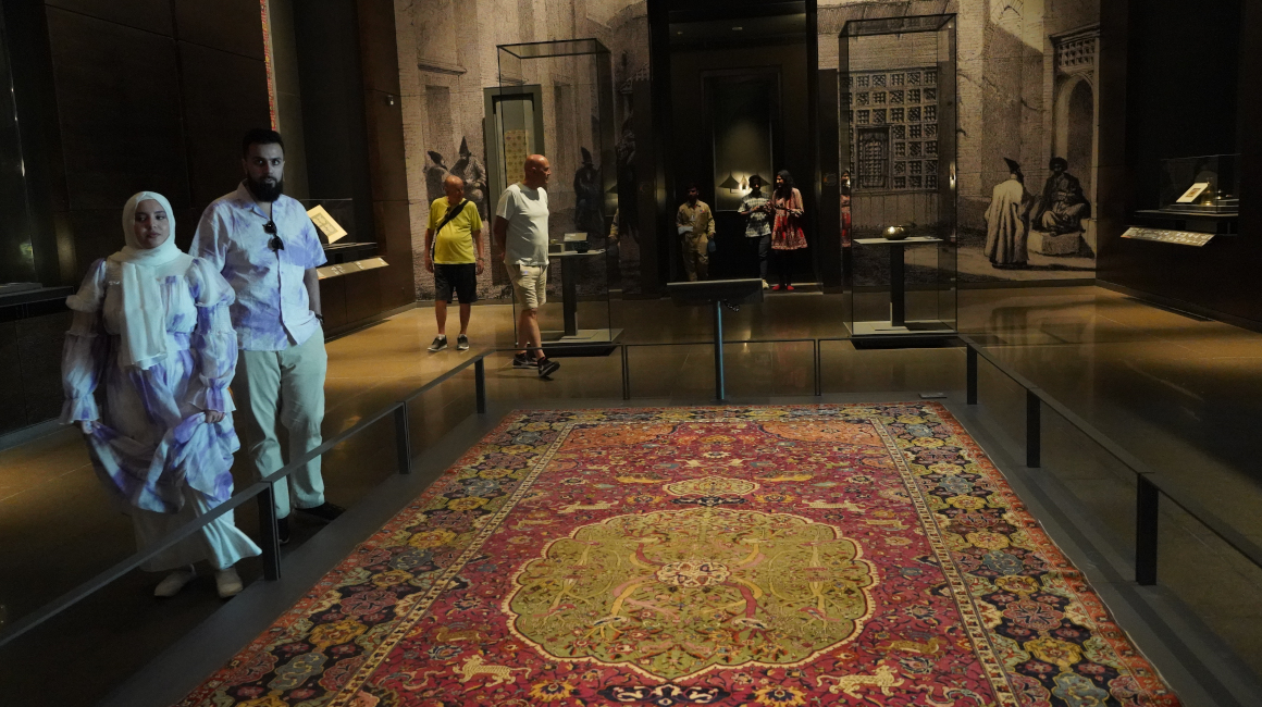 Personas locales y turistas extranjeros visitan el Museo de arte islámico en Doha, Qatar.